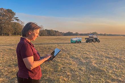D4754 1 Dr. Galina Yakubova in a field monitoring real-time measurements of soil carbon, captured by the Mobile Inelastic Neutron Scattering scanning system.
