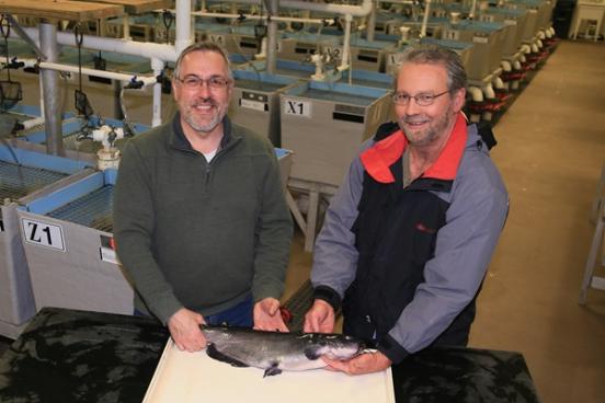 Two researchers holding a catfish