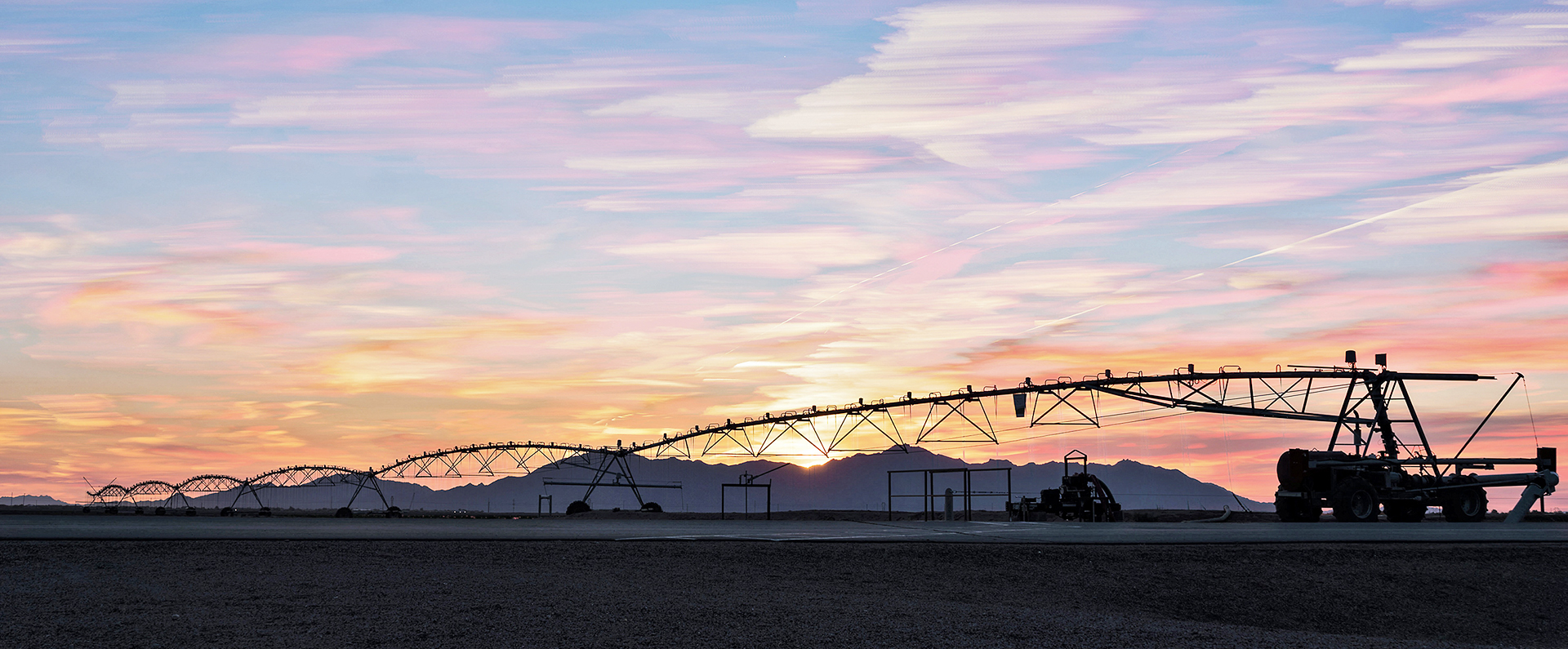 Sunset over lateral-move overhead irrigation system and the Estrella mountain southwest of Phoenix, Arizona.