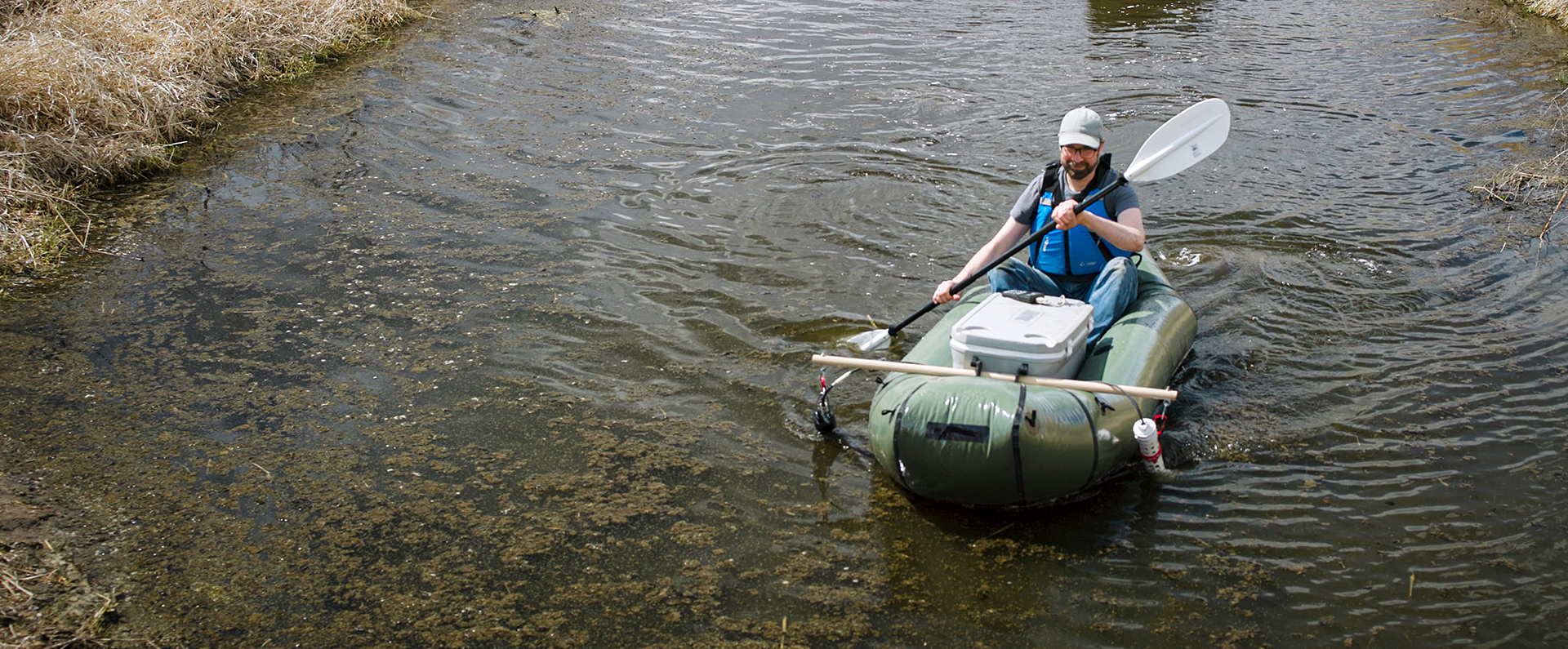 ARS researcher paddling in a stream.